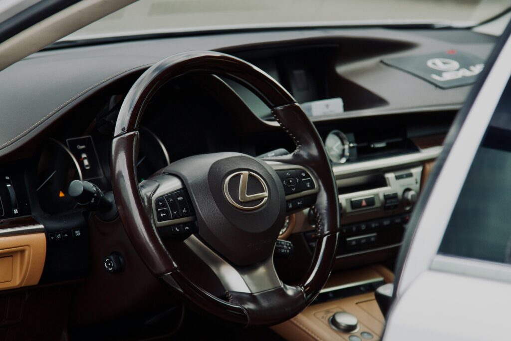 Close-up of a Lexus car interior highlighting the steering wheel in a luxury setting.